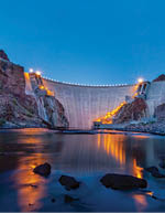 Roosevelt Dam, low on the water, looking up at dam face, dusk or evening with lights