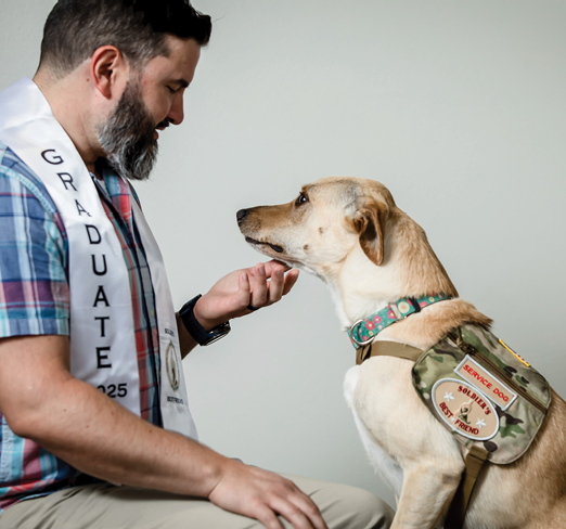 A man wearing a graduation sash is petting a dog. AI generated content