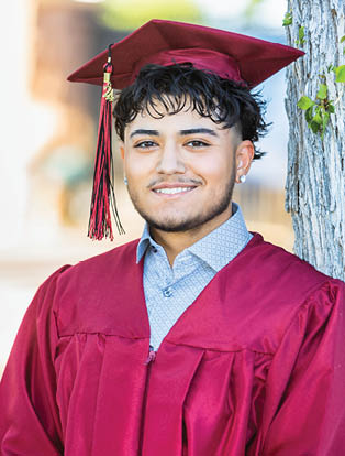 A man wearing a red graduation robe and a cap stands in front of a tree. AI generated content