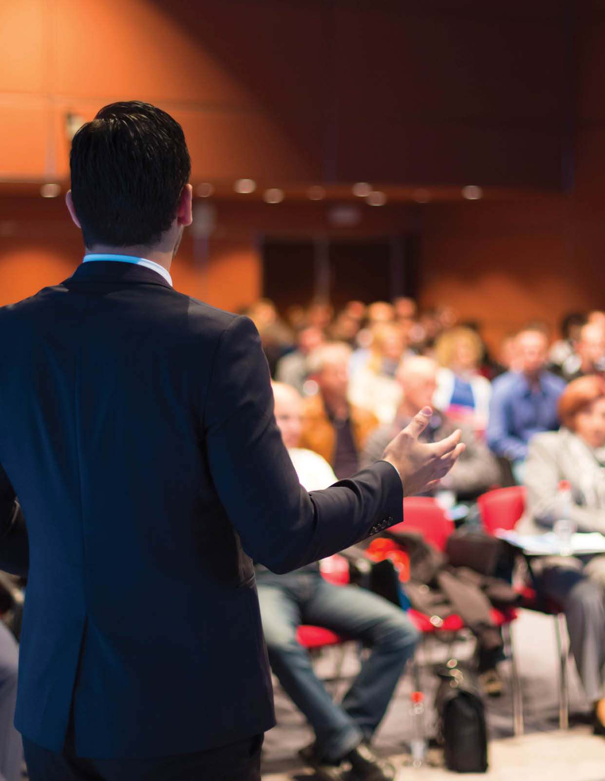 A man in a suit is giving a presentation to a group of people. AI generated content