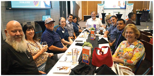 A group of people are sitting around a table with food and drinks. AI generated content