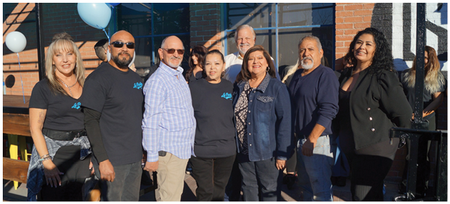 A group of people posing for a picture in front of a building. AI generated content