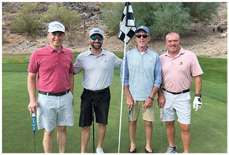 Four men are standing on a golf course, posing for a picture. They are holding golf clubs and wearing sunglasses. AI generated content