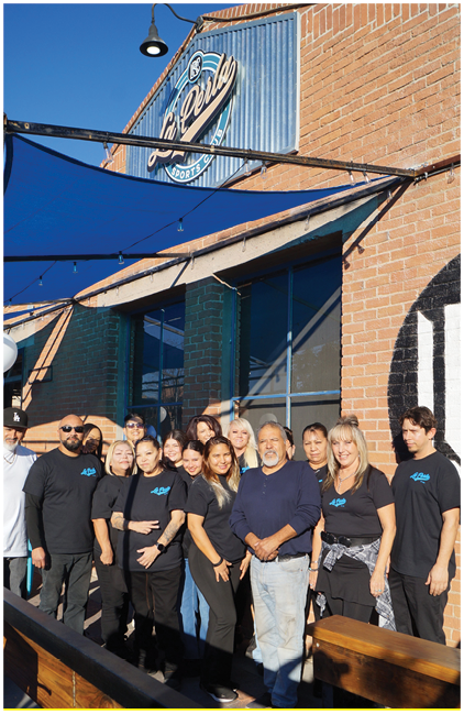 A group of people pose for a photo in front of a building. AI generated content