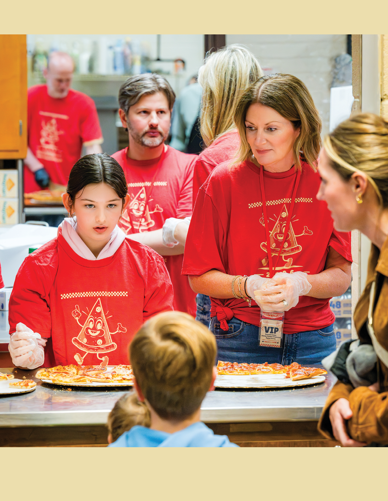 A group of people standing in a kitchen. Description generated by AI