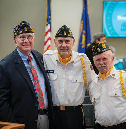Three men in uniforms pose for a picture. Description generated by AI