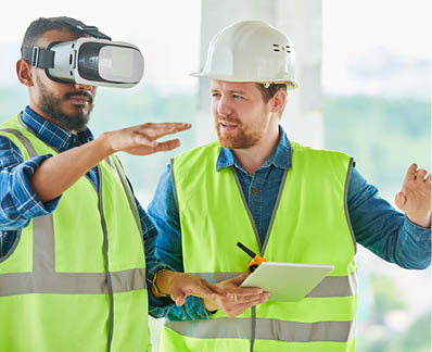 Concentrated handsome mixed race engineer with beard gesturing while using VR simulator for building visualization, his colleague explaining project to him