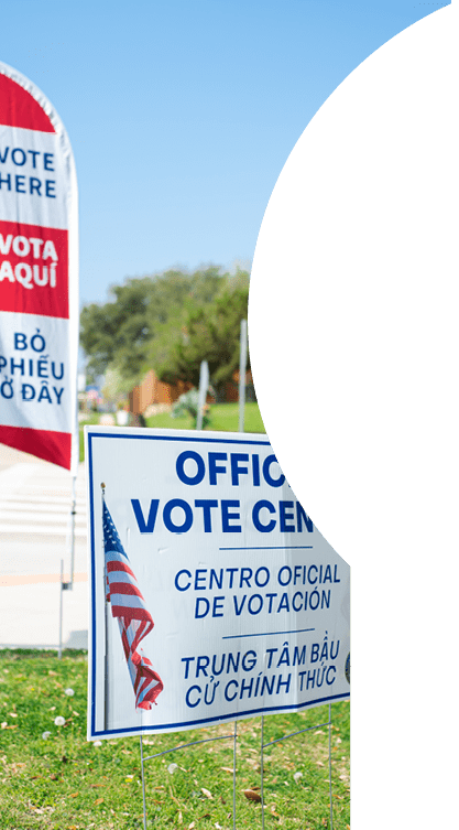 Residential street intersection with yard sign, vote banner flag show Official Vote Center in English, Spanish, Vietnamese welcome non-English-proficient groups to voting location Dallas, Texas. USA