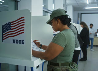 Female American army soldier votes in booth in polling station office. National Elections Day in the United States. Political races of US presidential candidates. Concept of civic duty. Dolly shot.