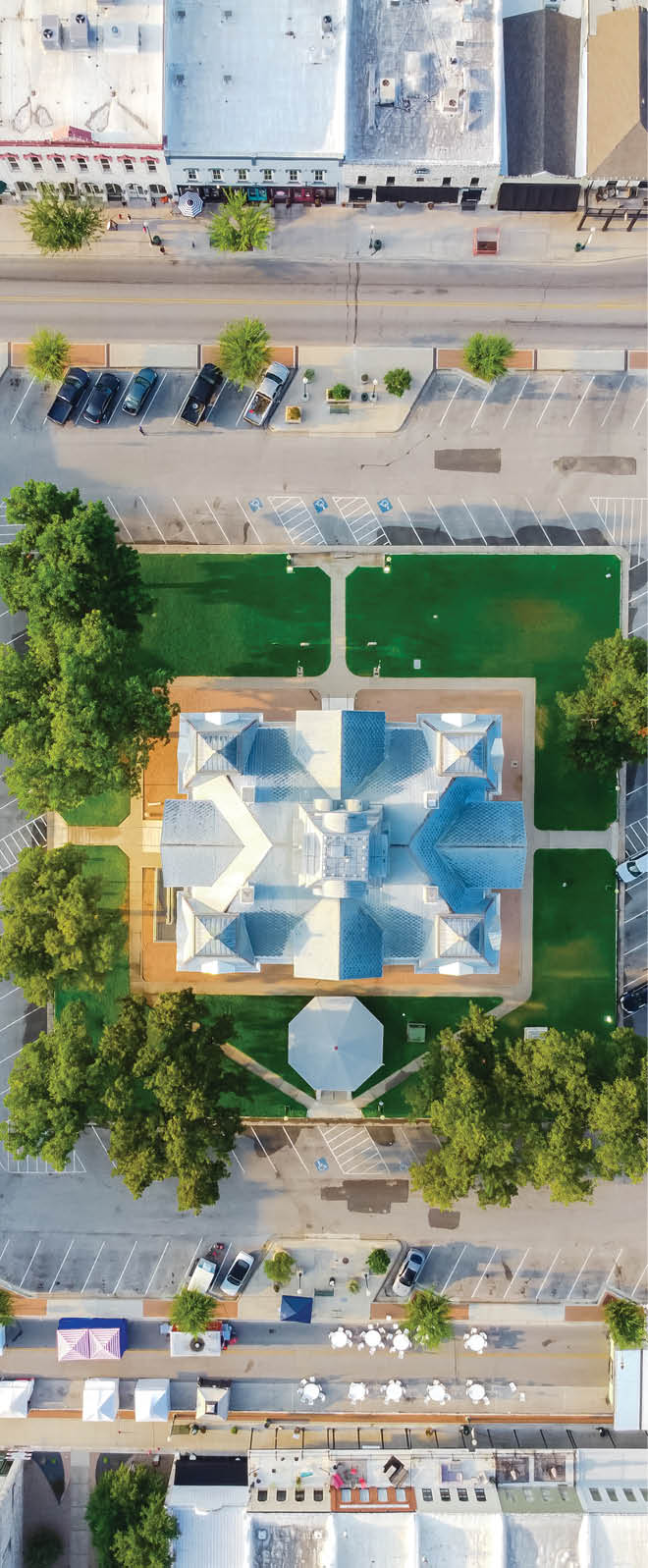 90 degree aerial view of Historic Hood County Courthouse in Downtown Square Granbury, Texas, USA. Greenery and seating for visitors with unique boutiques, restaurants, best charming small town list