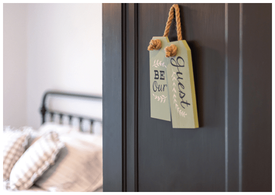 Guest bedroom - open door with sign that says “Be our guest"