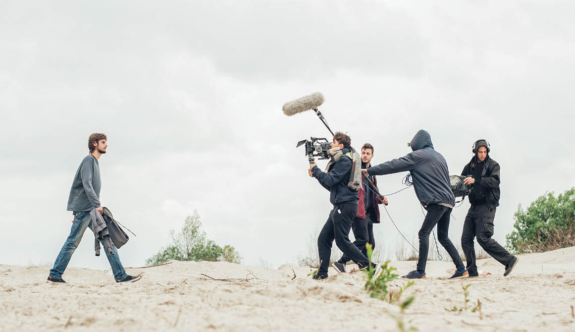 Behind the scene. Film crew team filming movie scene on outdoor location. Group cinema set