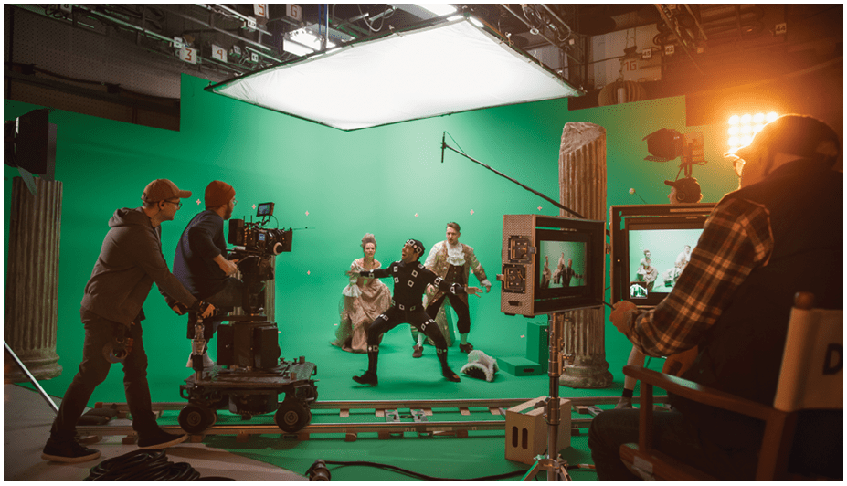 On Big Film Studio Professional Crew Shooting Period Costume Drama Movie. On Set: Directing Green Screen Scene with Gentleman Protecting Lady from Actor Playing Monster Wearing Motion Capture Suit