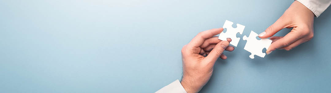 The man and woman holds in hand a jigsaw puzzle. Business solutions, success and strategy concept.