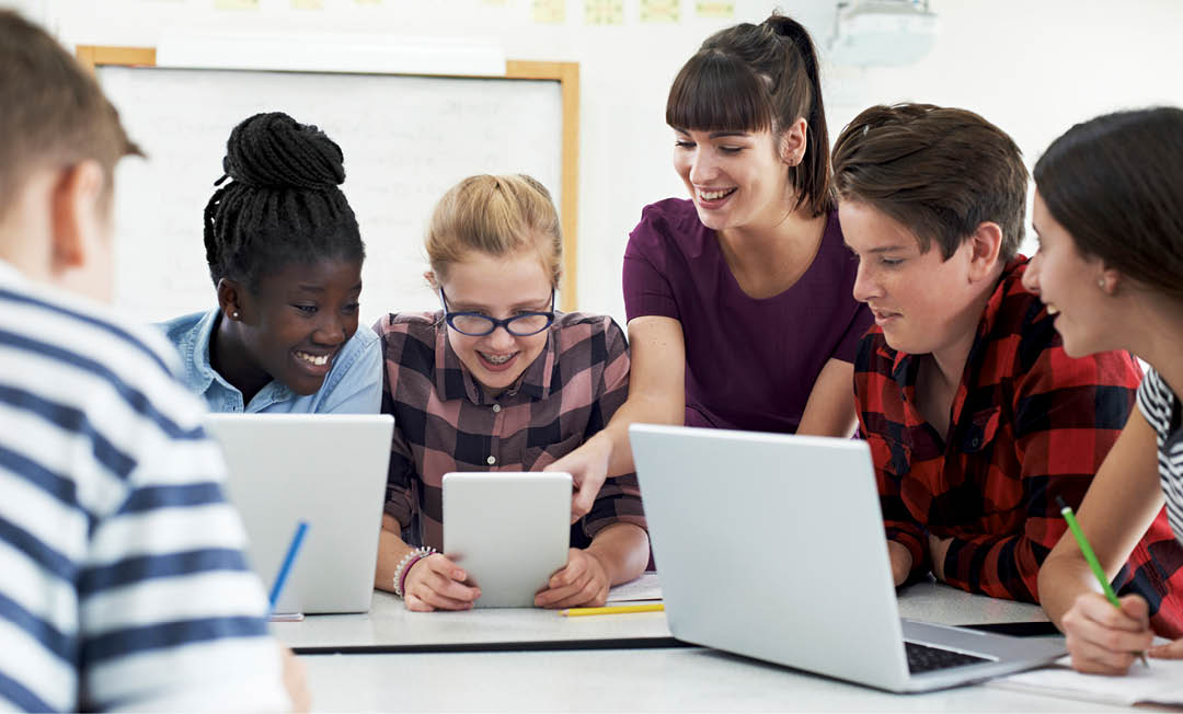 Teenage Students With Teacher In IT Class