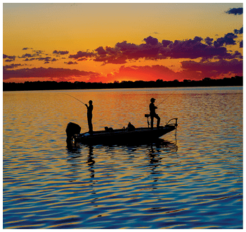 Fisherman in a boat at sunset with vibrant colors.