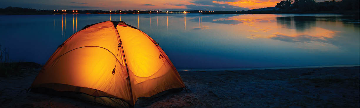 Orange tent on the lake at dusk. Dramatic red sky