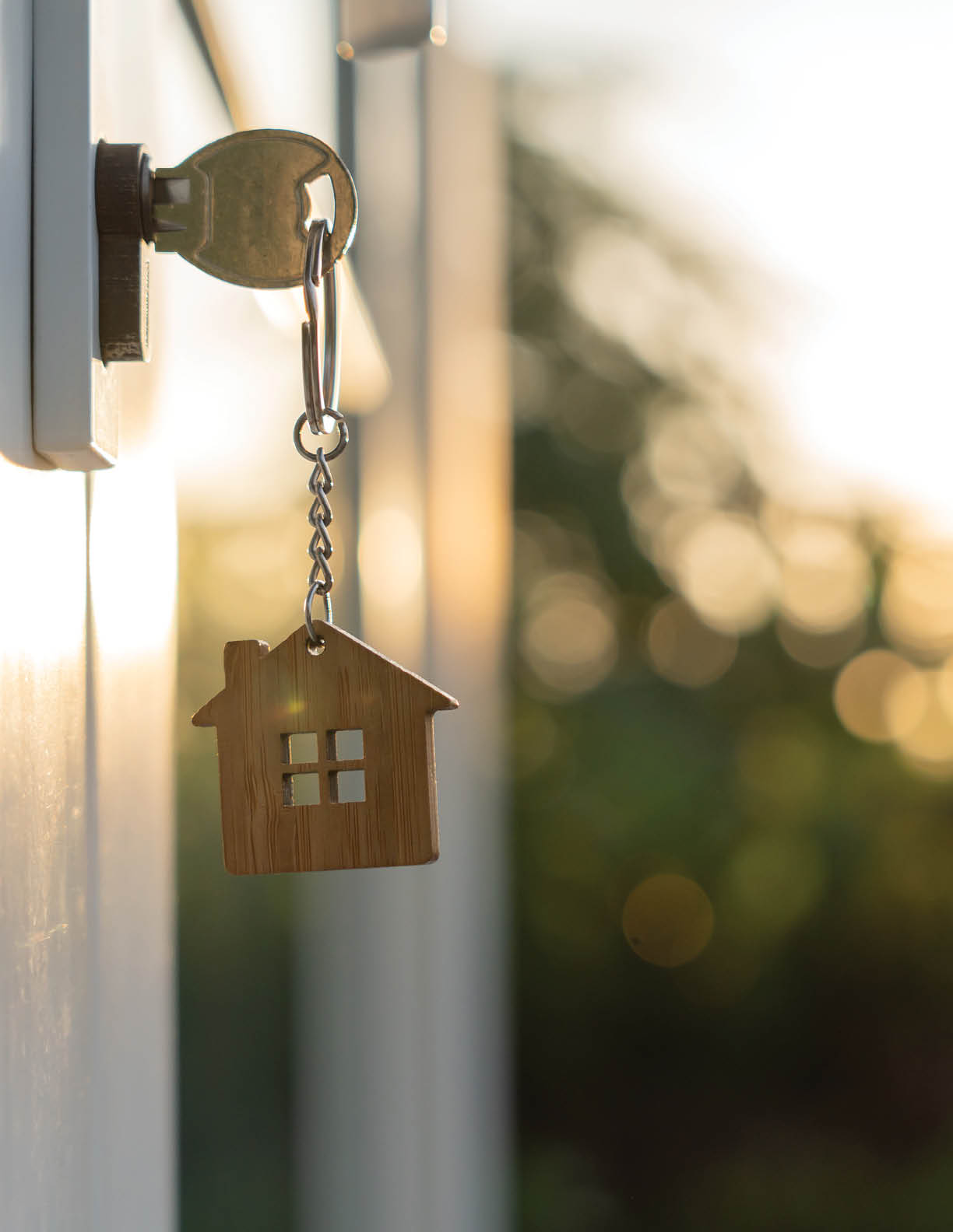 Landlord key for unlocking house is plugged into the door. Second hand house for rent and sale. keychain is blowing in the wind. mortgage for new home, buy, sell, renovate, investment, owner, estate