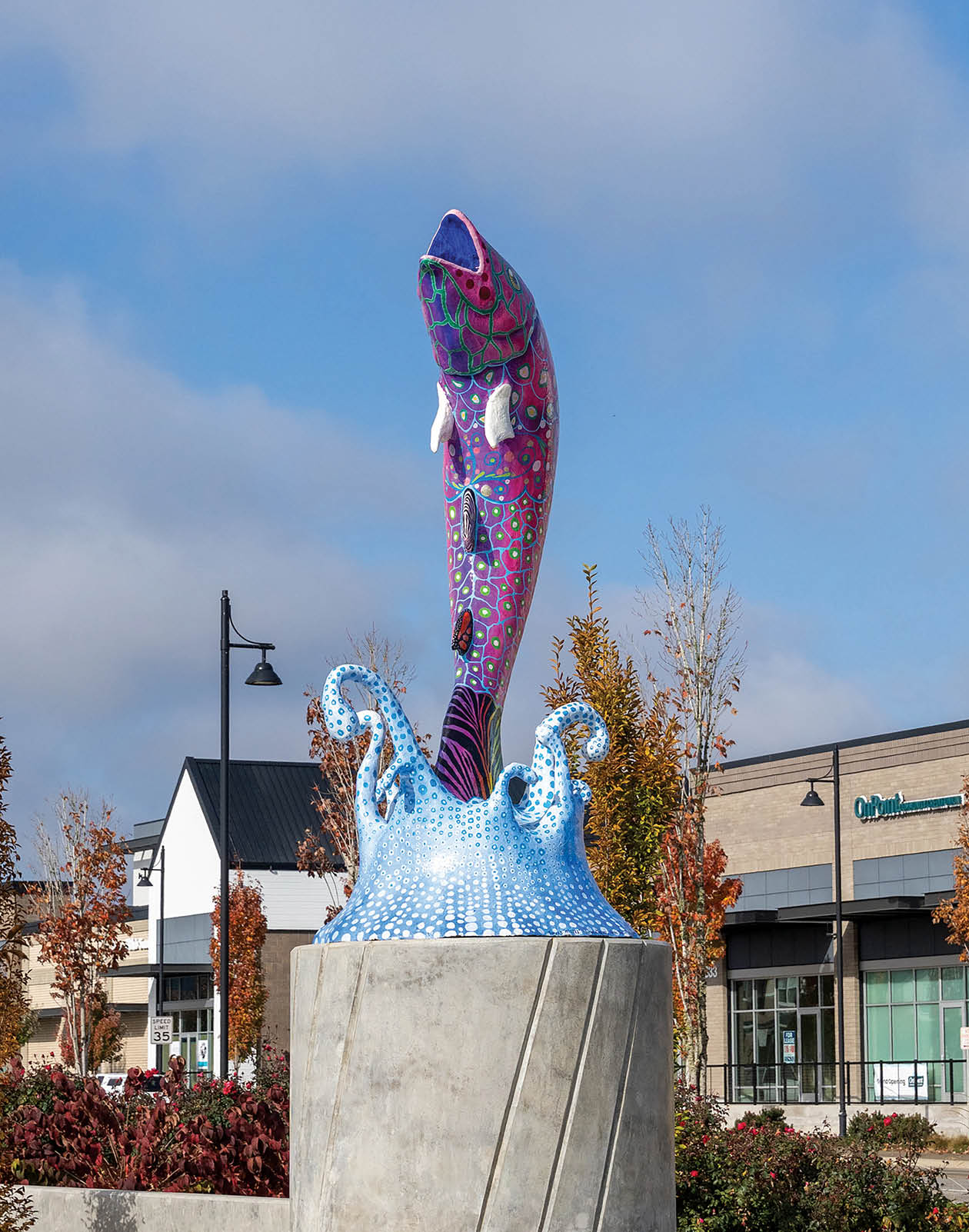 A fish statue is on a concrete base. Description generated by AI
