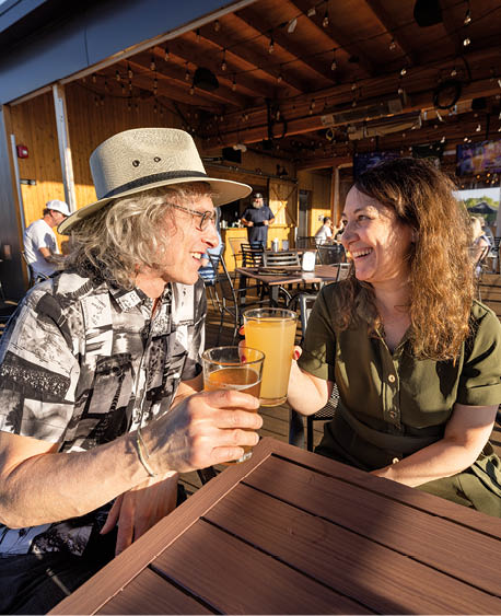 A man and woman sitting at a table with a drink in front of them. Description generated by AI