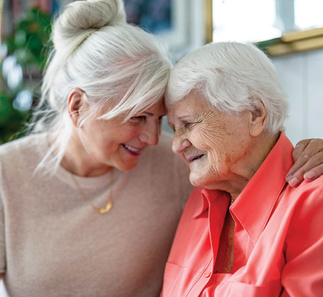Happy senior woman with her adult daughter at home