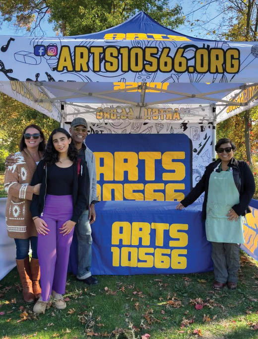 A group of people posing for a photo in front of a sign Description automatically generated