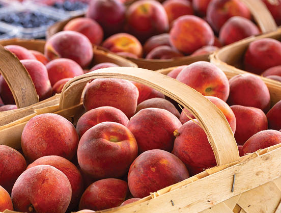 Fresh yellow peaches at an outdoor farmer's market