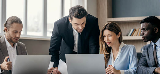 Confident business team using technologies and talking while having group meeting in the office