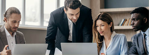 Confident business team using technologies and talking while having group meeting in the office
