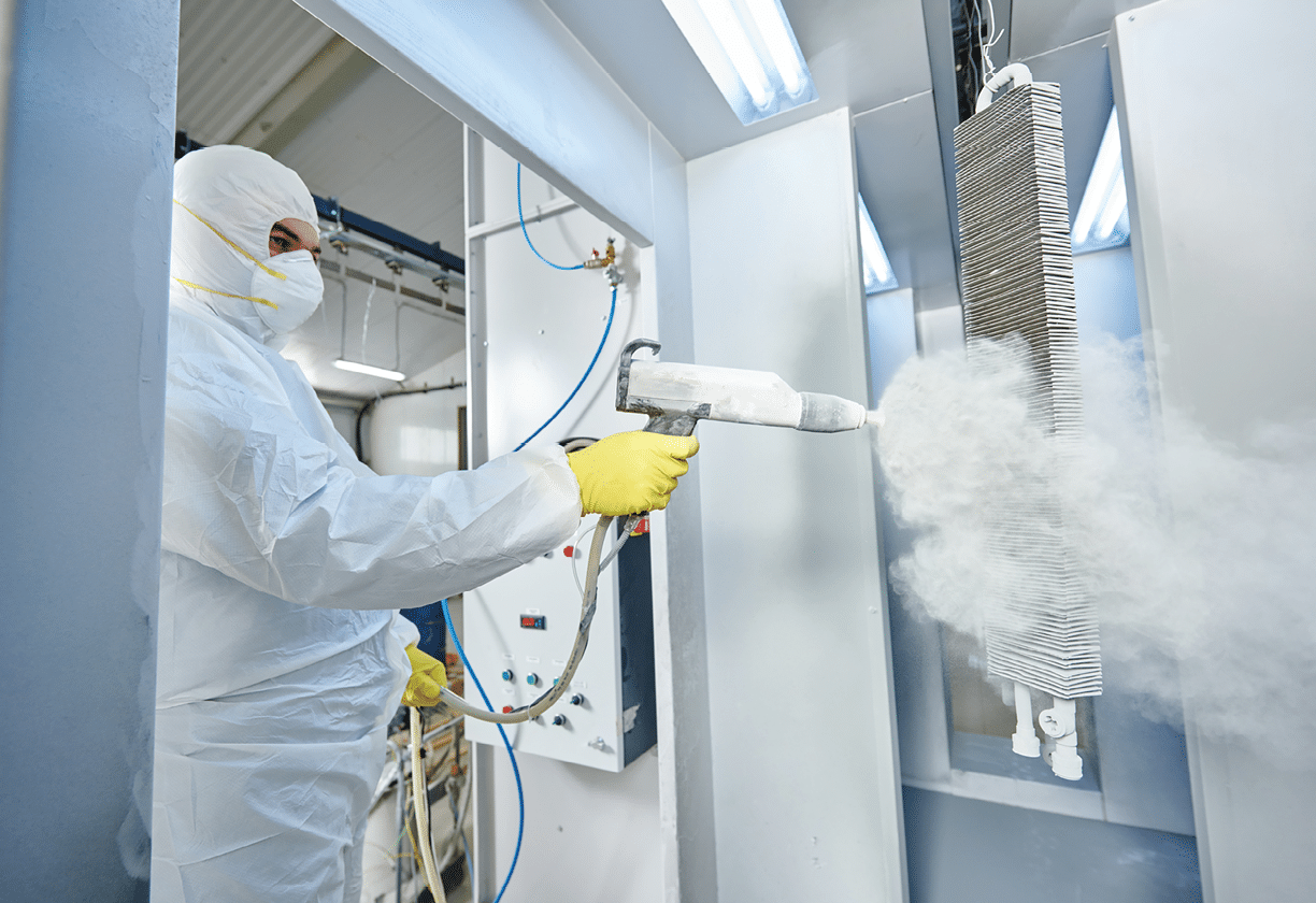 industrial metal coating  Worker man in protective suit with gas mask spraying powder to steel finished parts in painting chamber 