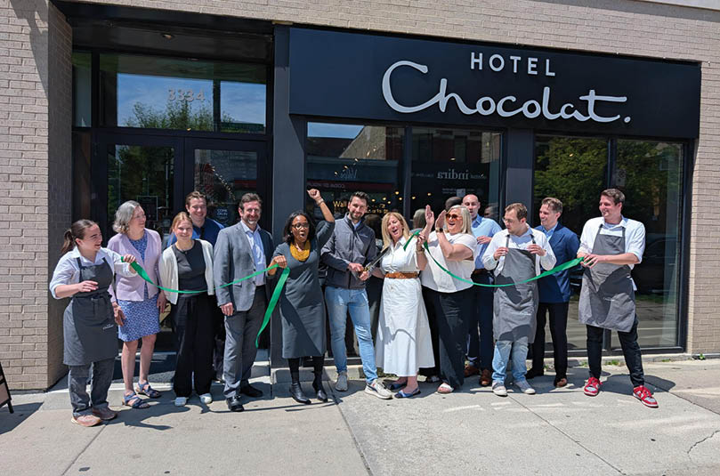A group of people standing in front of a hotel. Description generated by AI