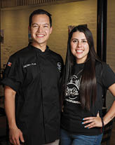 A man and woman standing in a restaurant. Description generated by AI