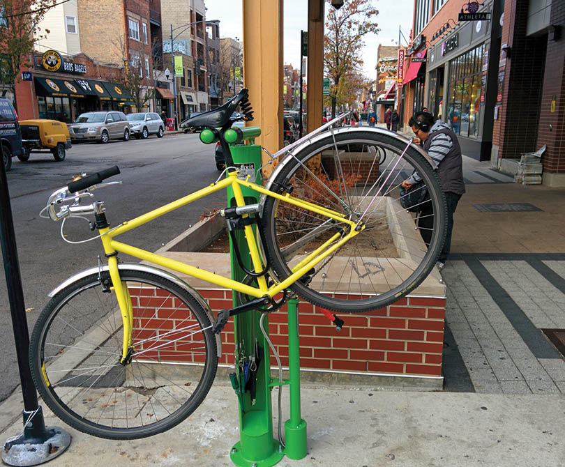 A yellow bicycle is locked to a green pole. Description generated by AI