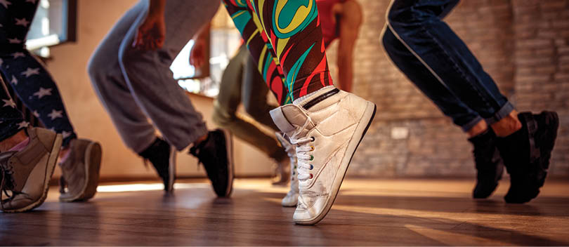 A person wearing white shoes and colorful pants is dancing. Description generated by AI