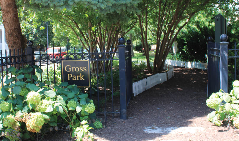 A sign is on a pole in a park. Description generated by AI