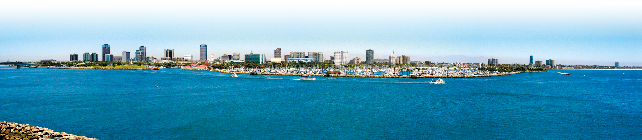 Boat marina in the Long Beach, California full of sailboats, yachts, and other motor operated boats. The panoramic view of the entire downtown area of Long Beach.