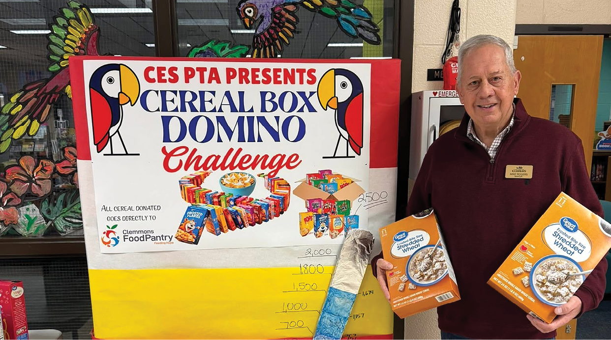 A man is holding boxes of cereal in front of a sign advertising a cereal challenge. AI generated content