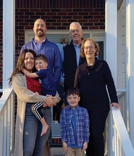 A family of six, including adults and children, pose for a photo on a porch. AI generated content
