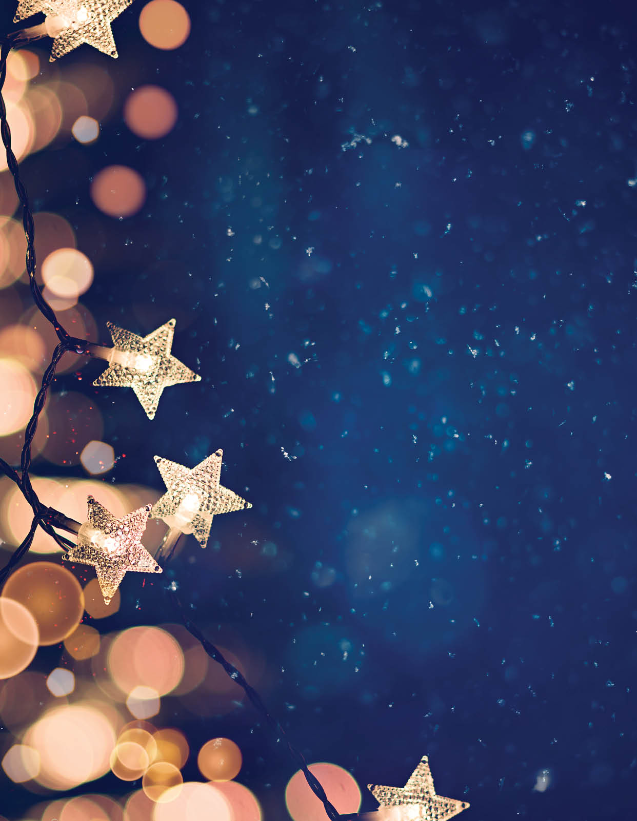 Star shaped Christmas string lights on blue night background with golden bokeh lights.