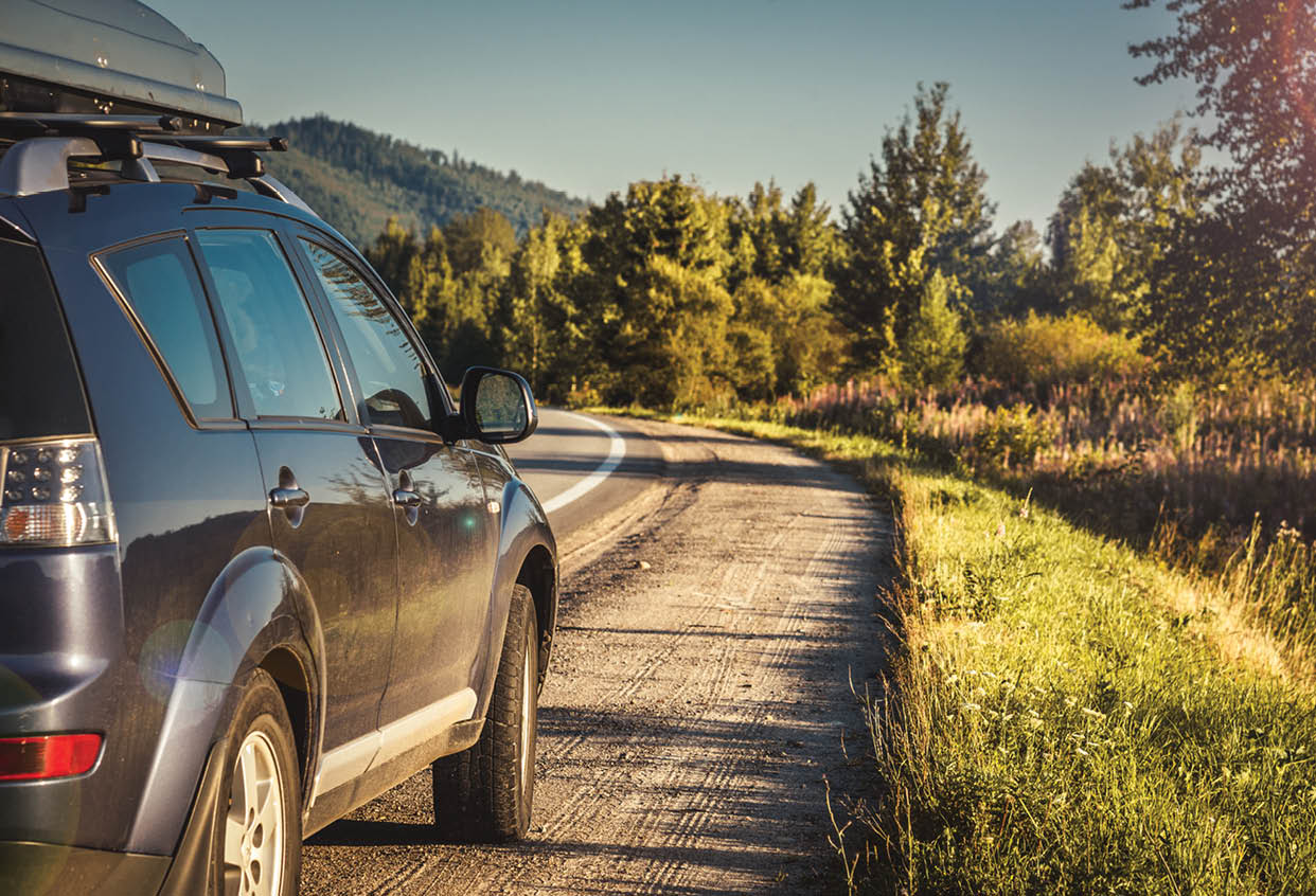A blue SUV is parked on a road next to a grassy area. AI generated content