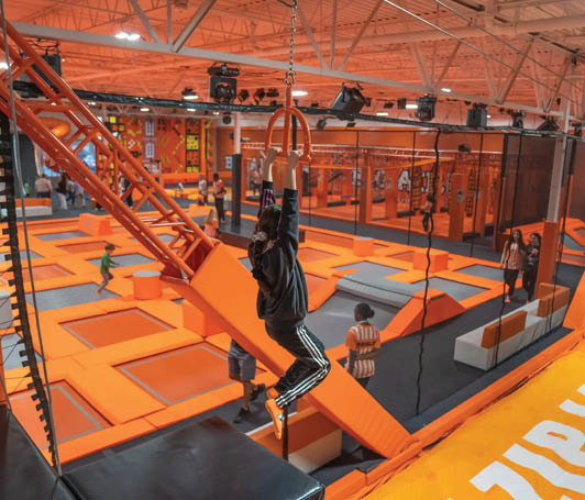 A person is on a trampoline in an indoor play area. Description generated by AI
