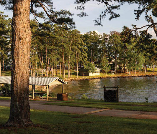 A park with a picnic area and a lake. Description generated by AI