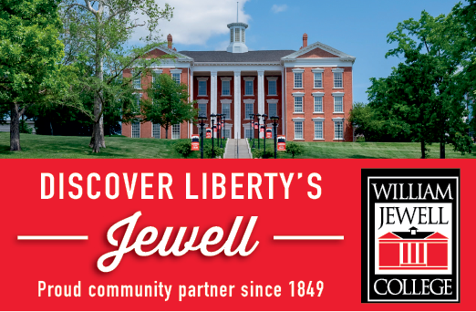 A red and white sign that says “Discover Liberty's Jewell" with a picture of a building in the background. Description generated by AI