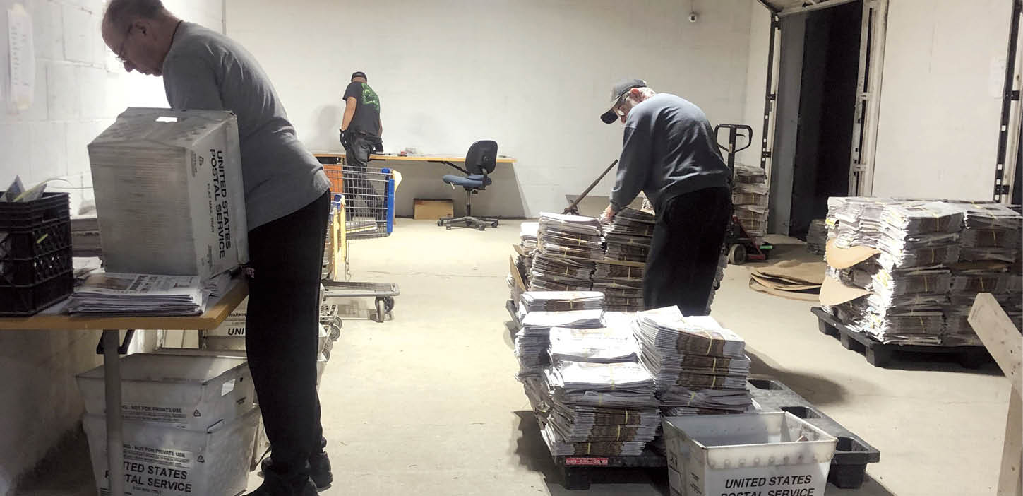 Chris Bell | The Lima News Dock workers sort newspapers before handing them off to carriers.