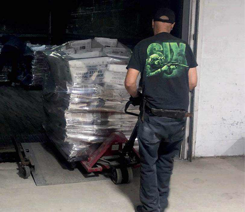 Chris Bell | The Lima News Dock crews pull pallets of The Lima News newspapers off a truck and into the distribution center.