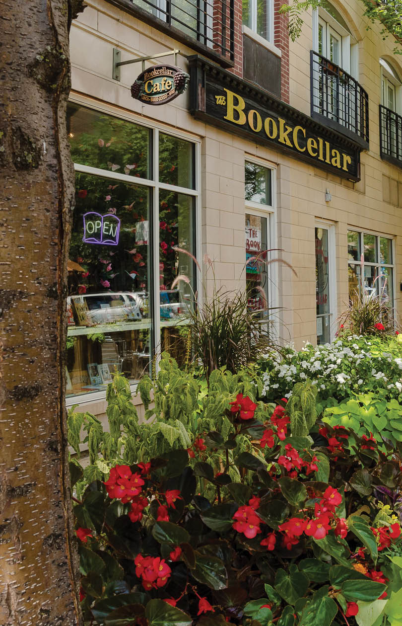 A tree with red flowers in front of a store. Description generated by AI