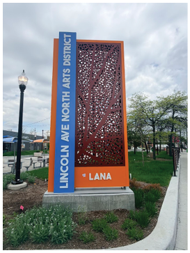A sign for Lincoln Avenue is on a sidewalk. Description generated by AI
