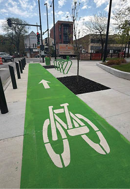 A green bike lane on a street. Description generated by AI