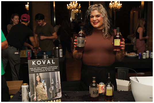 A woman holding a bottle of liquor. Description generated by AI