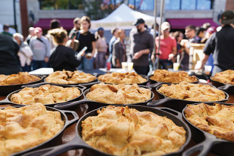 A table full of pies in a pan. Description generated by AI